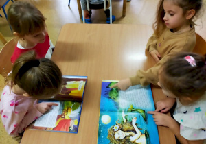 Dzieci oglądają książki z legendami i baśniami polskimi